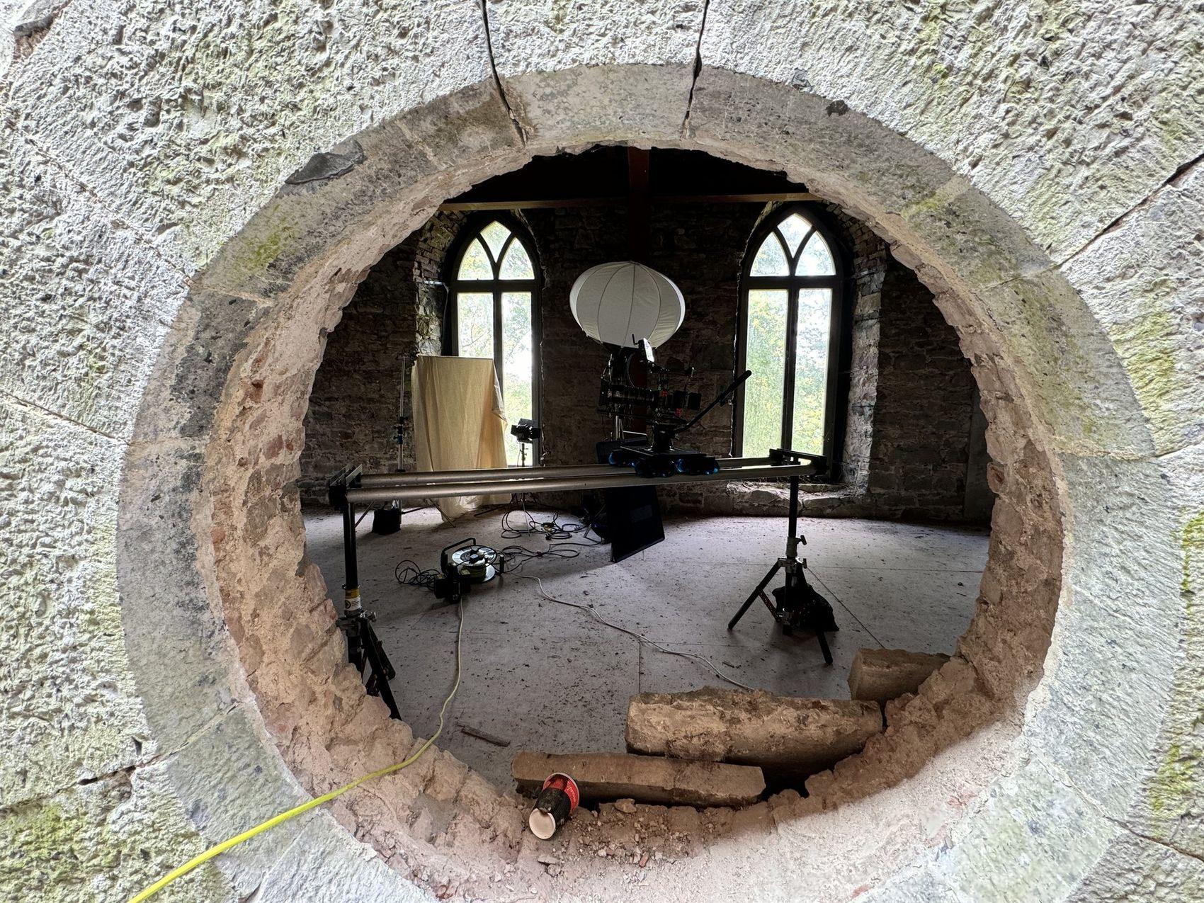 Dolly track and balloon light rigged inside a ruined chapel