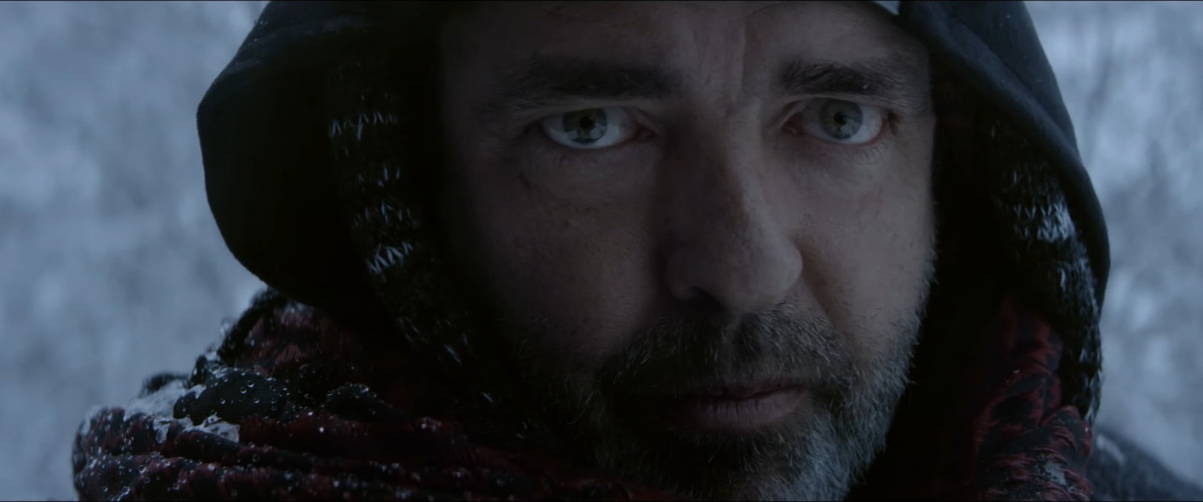 Production still — hooded figure in snow